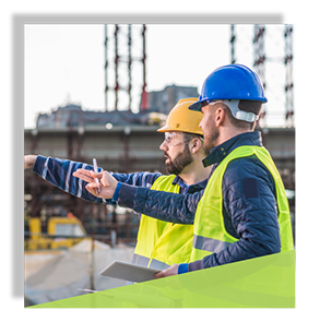 Two construction workers discussing and pointing at work site